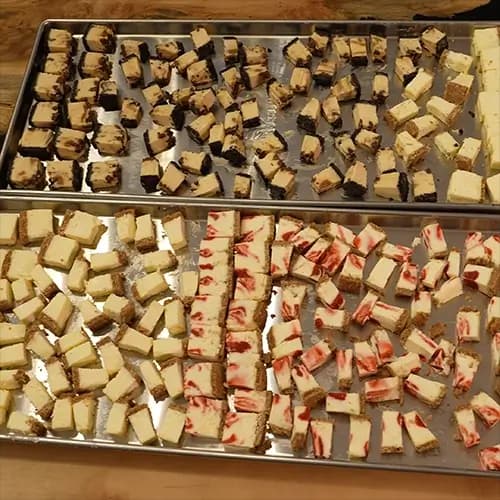 A variety of quartered and halved cheesecake bites spaced out on two Harvest Right medium sized trays.