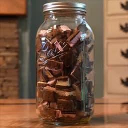 A mason jar packed with bite sized pieces of freeze dried Neapolitan ice cream sandwiches.