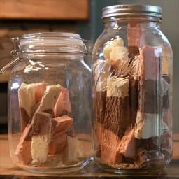 Two mason jars filled with freeze dried Neapolitan ice cream bars.