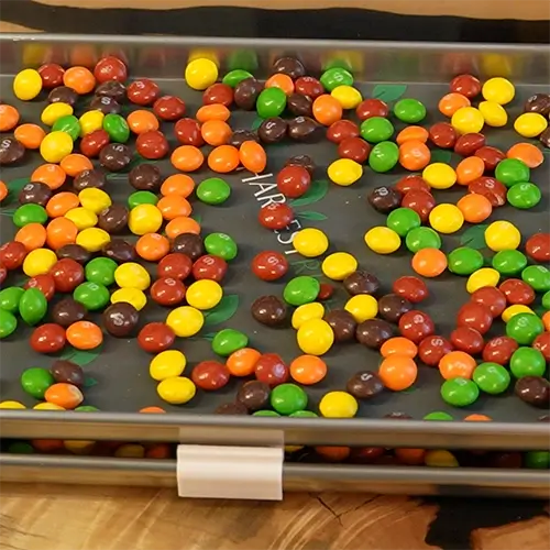 A medium harvest right freeze drying tray covered in Skittles ready to go into the freeze dryer.