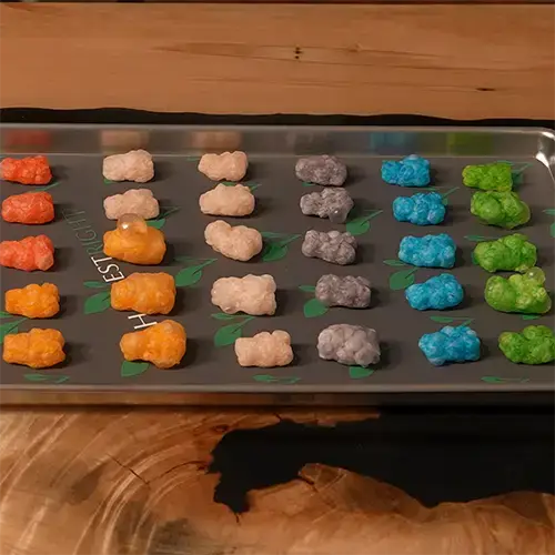 Columns of 5 freeze dried gummy bears arranged neatly on a medium harvest right freeze dryer tray. 