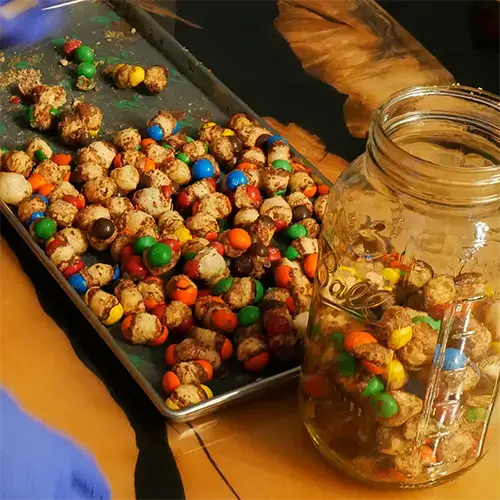 A mason jar and a Harvest Right tray with freeze dried Caramel M&M's.