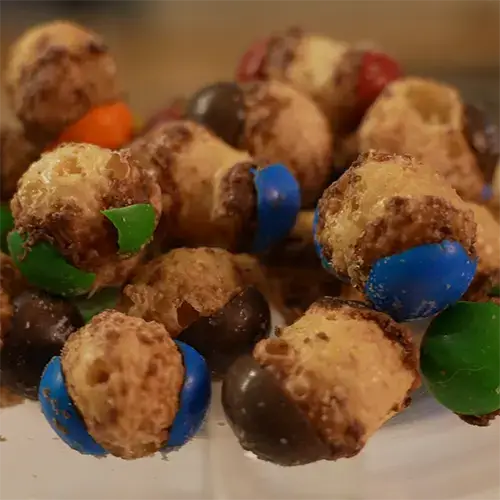 A group of freeze dried Caramel M&M's stacked on top of each other showing the texture of each one.