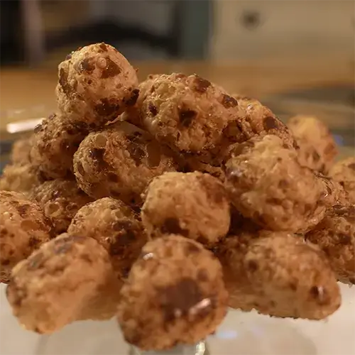 Many stacked freeze dried Milk Duds close up to display the texture of each Milk Dud.