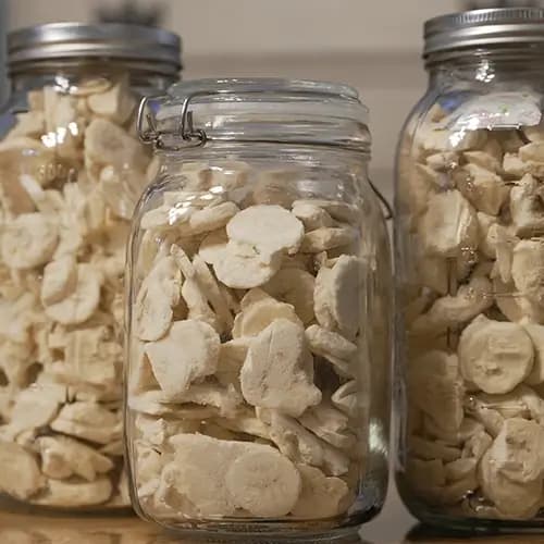 Three mason jars filled with freeze dried bananas.