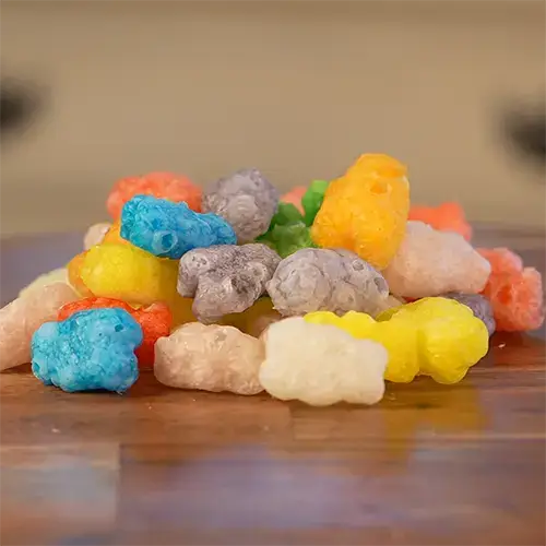 An array of vibrantly colored freeze dried gummy bears in a pile.